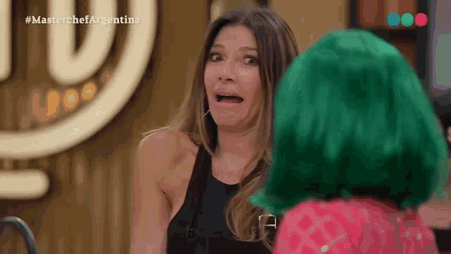 a woman in a green wig talks to another woman