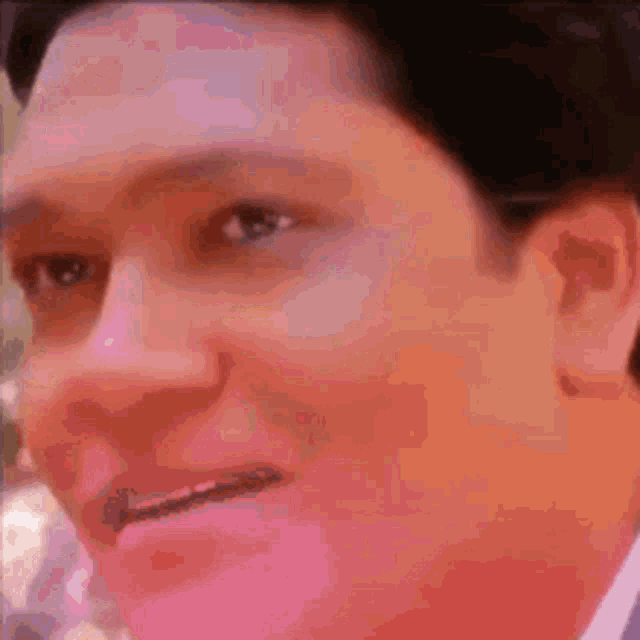 a close up of a man 's face with a blurred background .