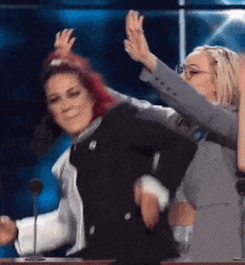a woman with red hair is dancing with another woman