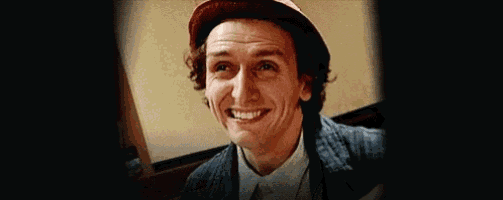 a close up of a man wearing a hat and laughing .