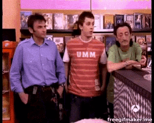 a man wearing a shirt that says umm is standing with two other men
