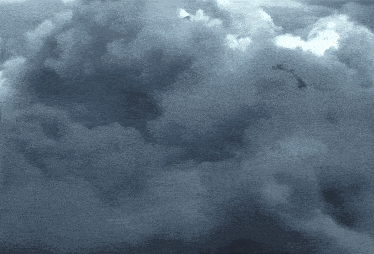 a dark cloudy sky with a few birds flying through it