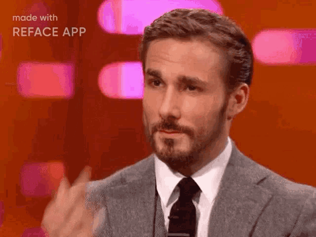 a man with a beard in a suit and tie is giving the middle finger
