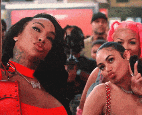 a group of women are posing for a picture and one of them has a necklace that says ' swag ' on it