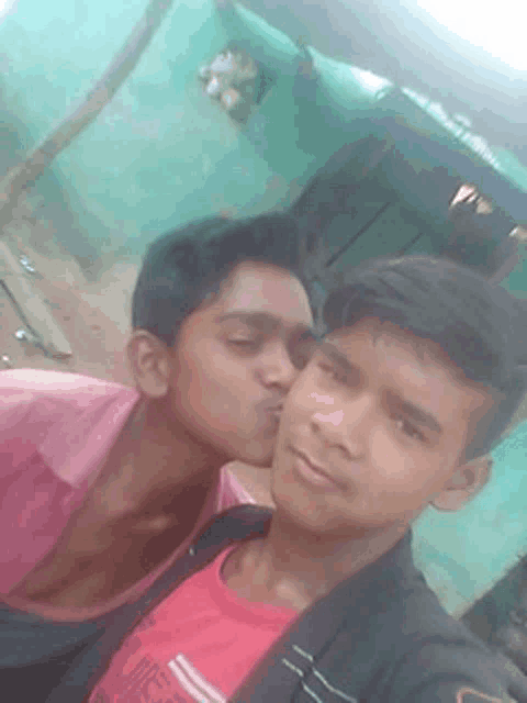two young men are kissing each other on the cheek while posing for a picture .