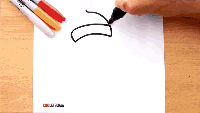 a person is drawing a banana on a piece of paper
