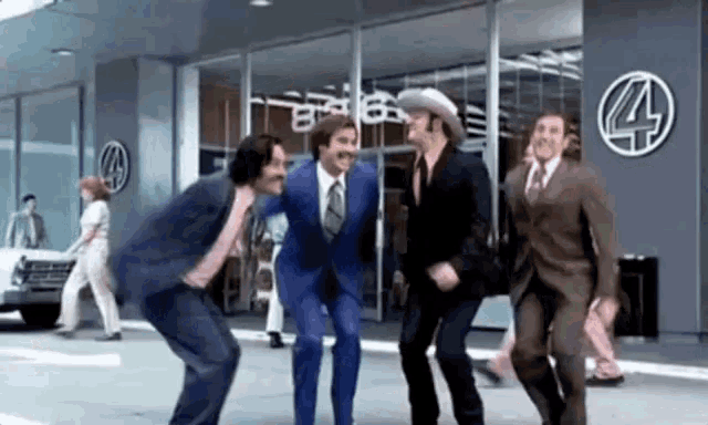 a group of men in suits and ties are dancing in front of a store .