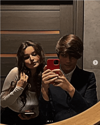 a man and a woman are taking a picture of themselves in a mirror