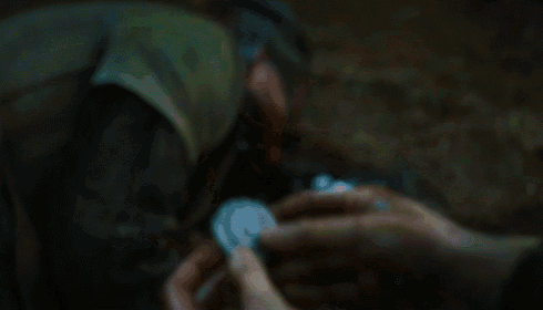 a person holding a coin in their hands with blood on their hands