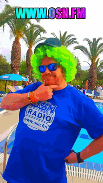 a man in a green wig and sunglasses is wearing a blue shirt that says www.osn.fm