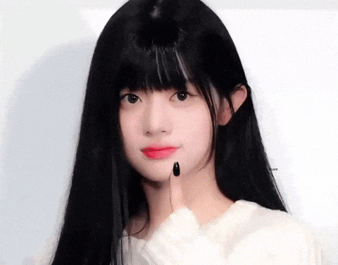a girl with long black hair and black nails is making a funny face
