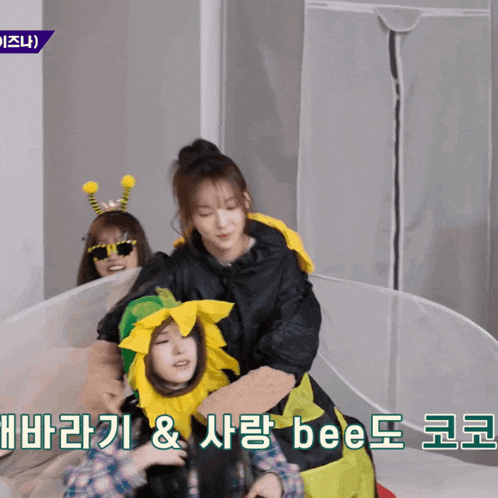 a woman in a bee costume hugs another woman in a sunflower costume