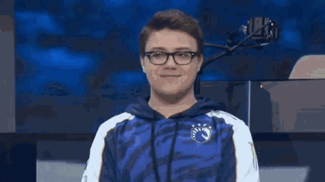 a young man wearing glasses and a blue and white hoodie with a monster energy logo on it