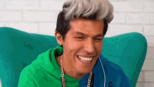 a man is sitting in a chair wearing headphones and smiling .