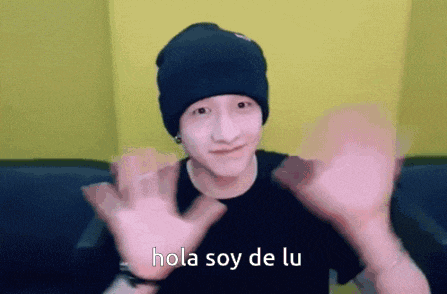 a young man wearing a black beanie and a black shirt is waving his hands and says hola soy de lu