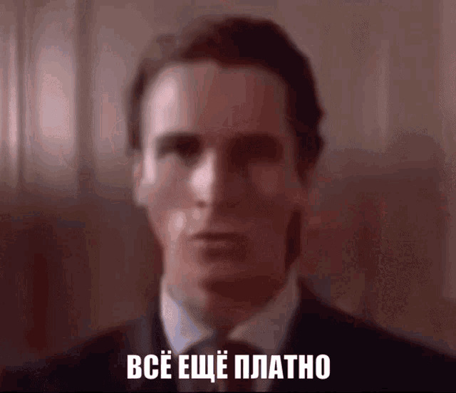 a man in a suit and tie says " все еще платно " in a foreign language