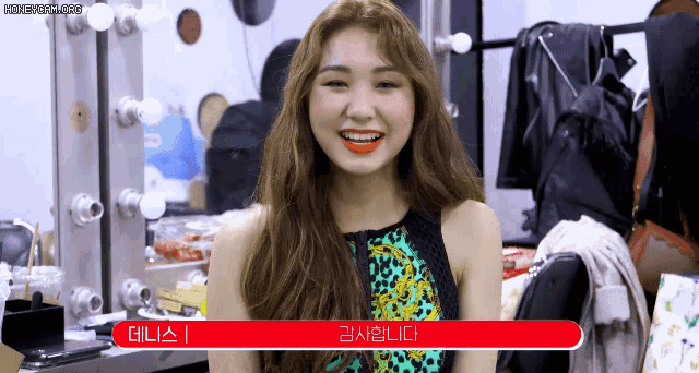 a woman in a leopard print top is smiling in front of a mirror with a red border that says honeycam.org on it