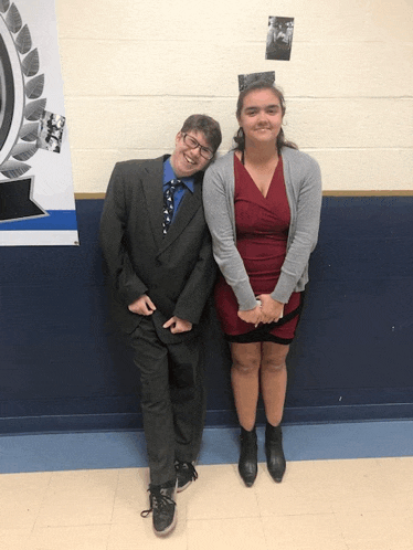 a man in a suit and tie and a woman in a red dress pose for a picture