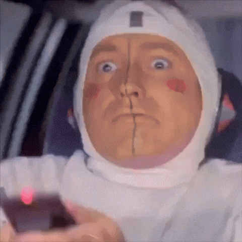 a man wearing a white helmet looks surprised and shocked