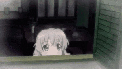 a girl is peeking out of a window .