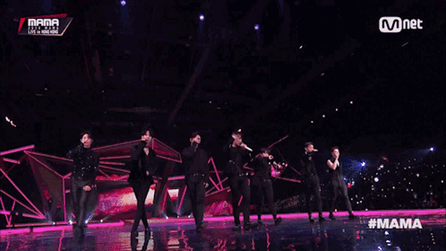 a group of men are dancing on a stage with a mnet logo in the corner