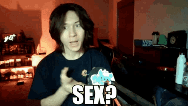a man in a dark room with the word sex on his shirt
