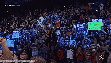 a crowd of people holding signs including one that says becky club