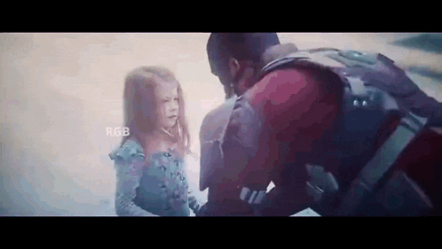 a man and a little girl are standing next to each other and looking at each other .