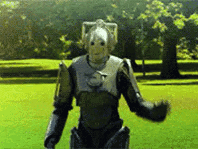 a robot is standing in a grassy field with his arms outstretched .