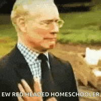 a man in a suit and tie is making a funny face and says `` ew red headed homeschooler '' .