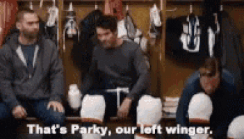 a group of hockey players are sitting in a locker room and one of them is talking about their left wing .
