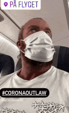 a man wearing a face mask and a t-shirt that says " coronaoutlaw "