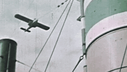 a small plane is flying over a boat in the sky .