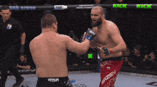 two men are fighting in a cage and one of them is wearing a pair of venum shorts