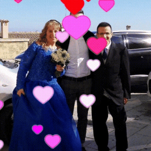 a woman in a blue dress stands next to a man and a man in a suit
