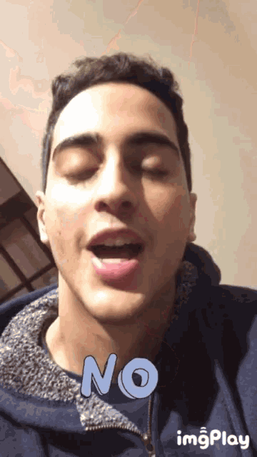 a young man with his eyes closed and the word no written on his face