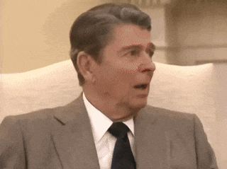 a man in a suit and tie is making a funny face