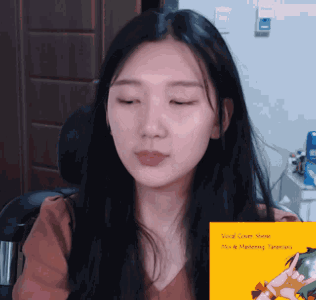 a woman with her eyes closed behind a sign that says vocal cover shene