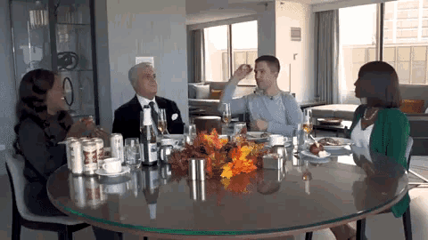 a group of people are sitting around a table with a bottle of beer that says ' a ' on it