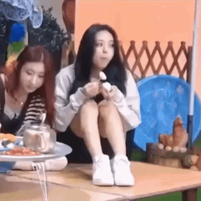 a woman is sitting on a table eating a piece of food .