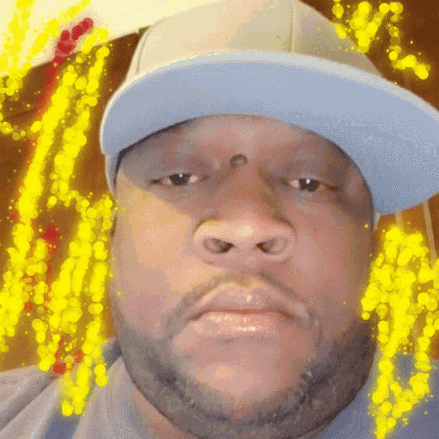 a man with a beard wearing a blue hat looks at the camera