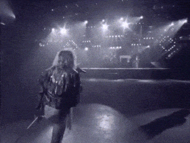 a black and white photo of a person holding a microphone
