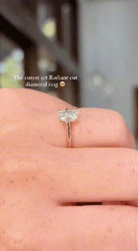 a close up of a diamond ring on a person 's finger