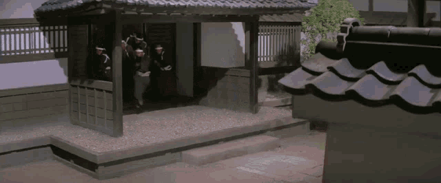 a group of men are standing outside of a building