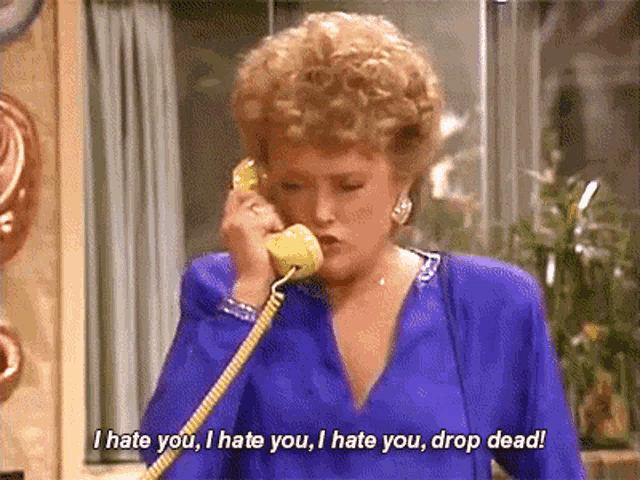 a woman is talking on a yellow phone and says i hate you