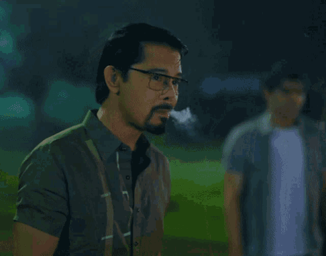 a man with glasses and a beard looks down