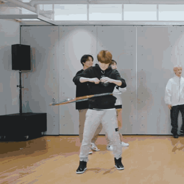 a man holding a hula hoop in a room with other people