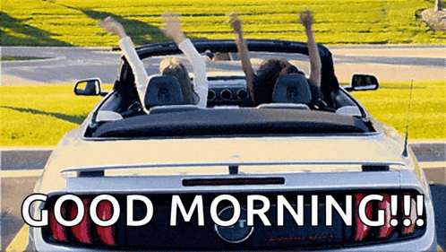 two people are sitting in a convertible car with their arms in the air and the words good morning written on the back .