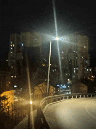 a street light shines brightly at night in a city