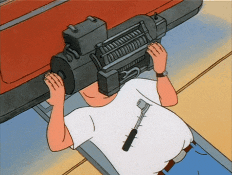 a man in a white shirt is laying on a lift with a winch on his head